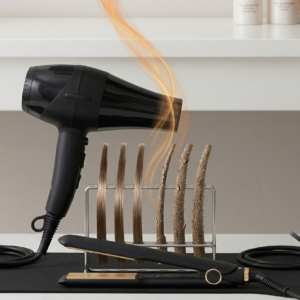 A comparison showing healthy hair strands next to dry, cracked hair strands being exposed to heat from a hair dryer and a flat iron