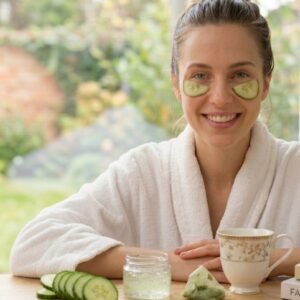 Woman relaxing at home with cucumber slices under her eyes for natural dark circle treatment and under-eye skincare routine