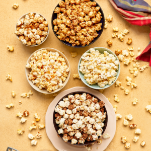 Air popped popcorn in bowls with a warm yellow and light brown background for healthy low calorie snacks for weight loss