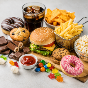 Foods to avoid for belly fat including fast food, fries, soda, donuts, chips, cookies, candy, and sugary snacks