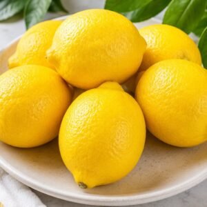 Fresh whole lemons arranged on an elegant plate, one of the Best Vitamin C Fruits for Glowing Skin.